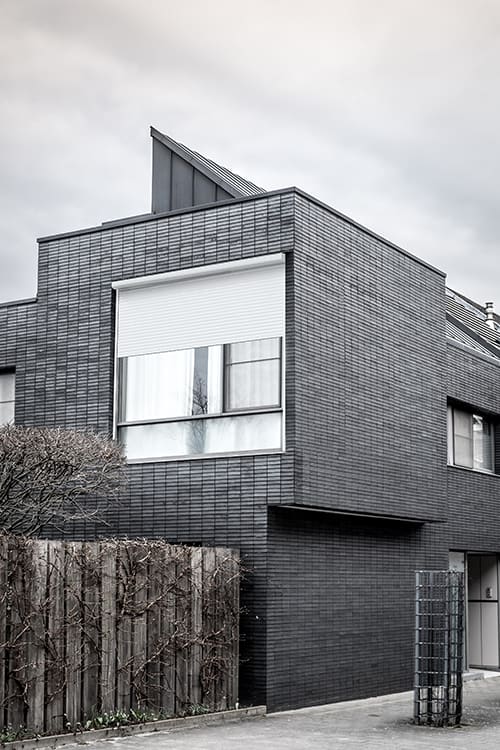 Vue d'extérieur d'une maison en noir et blanc avec un volet roulant astrolux renolux de la marque Flip