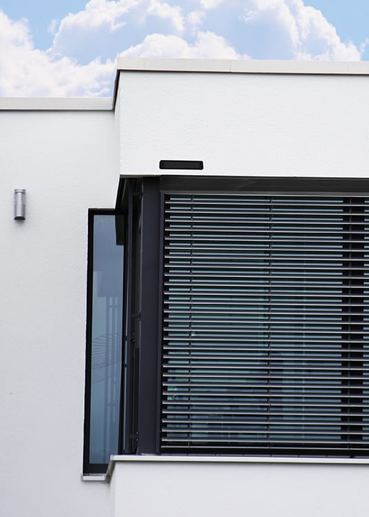 Maison blanche avec un brise soleil orientables rénovation solaires noir de la marque Flip