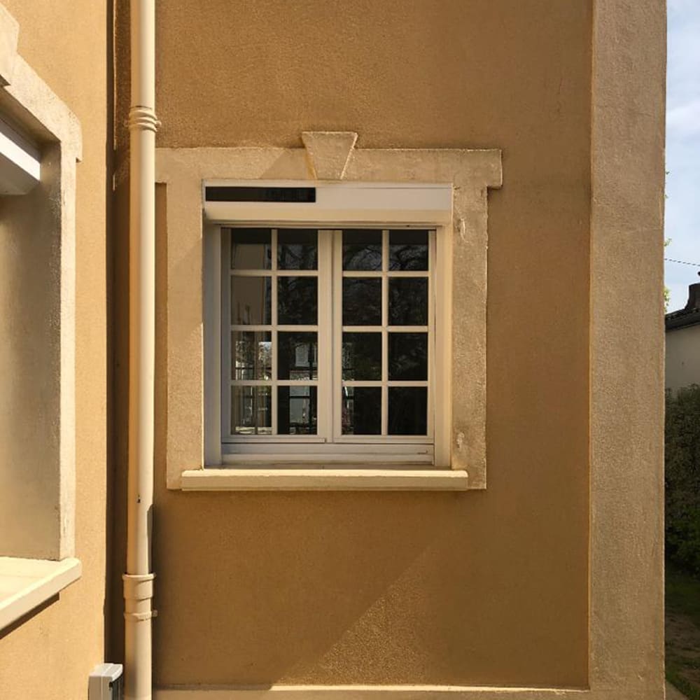 Façade de maison en crépis marron clair avec volet roulant Renosun astrosun de la marque Flip