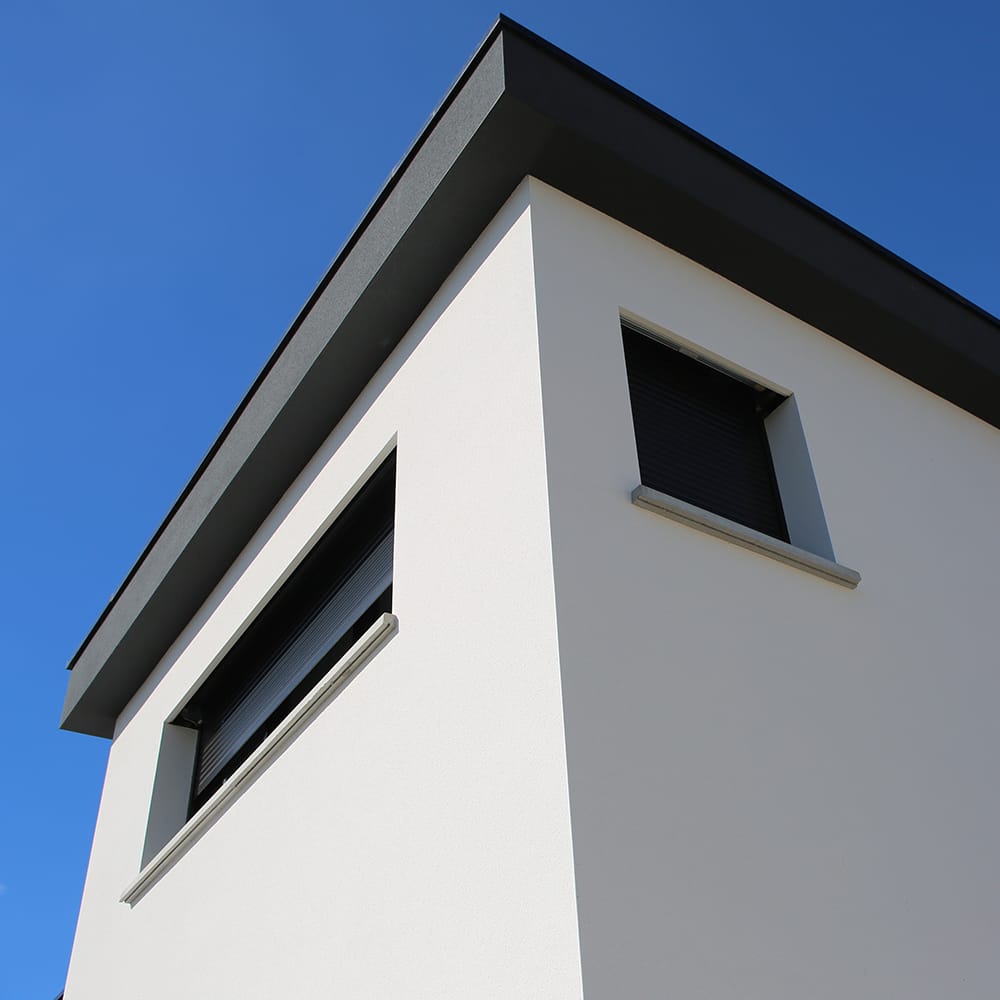 Façade de maison moderne blanche avec des volets tradi noir rénovation